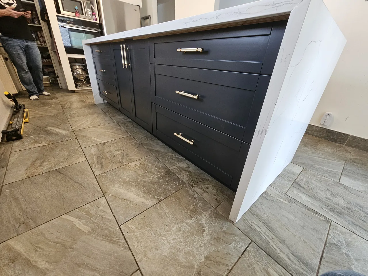 Navy island with a quartz waterfall edge and brass pulls