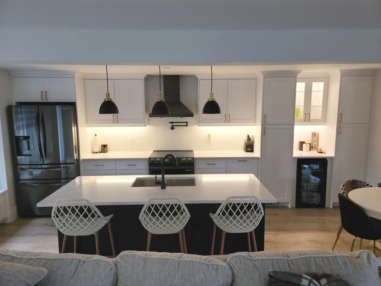 White kitchen with a large island and black pendant lights