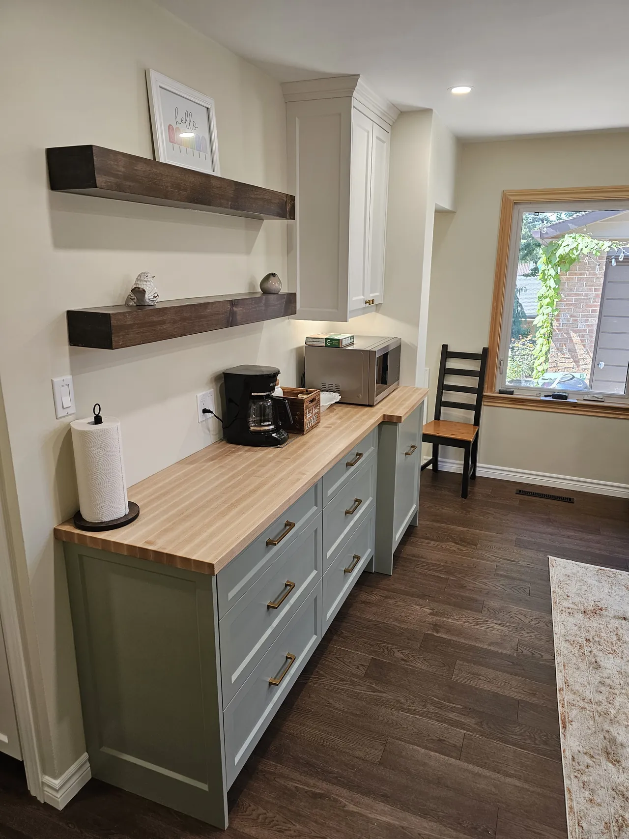 Sage green coffee station with floating walnut shelves