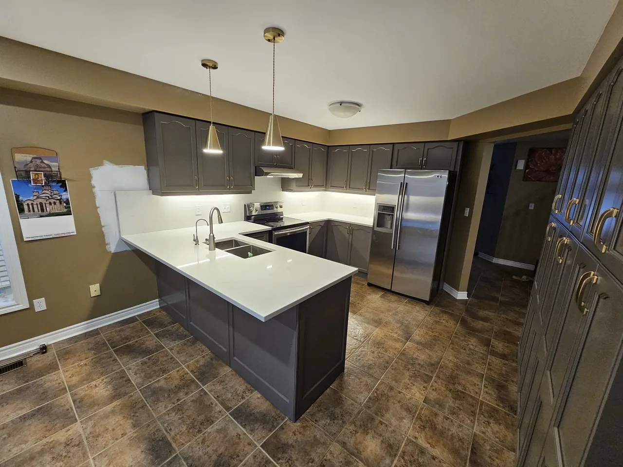 Resprayed charcoal cabinets and peninsula with a white quartz top