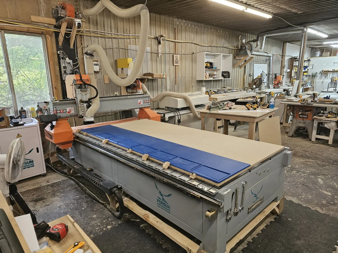 CNC router with blue panels on the bed in the Hailey Inc shop in Guelph